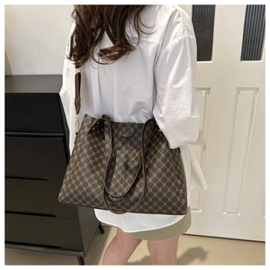 Dettaglio di borsa tote vintage capiente con motivo classico e tracolla larga