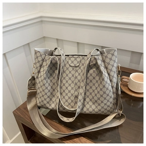 Dettaglio della borsa tote grigia monogrammata con fibbie dorate e tracolla in nylon