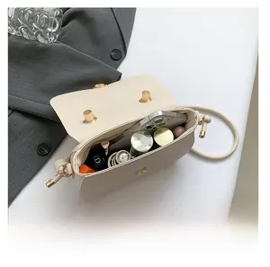 Top view showing the spacious interior of the beige lychee grain leather saddle bag