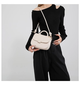 Chic cream white pebble leather handbag detail with knotted strap and circular top handle