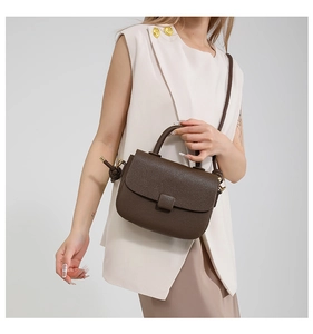 Elegantly styled crossbody bag in dark brown lychee grain leather on model