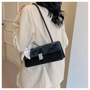 Détail du sac à bandoulière en velours noir avec boucle strass et accessoire foulard à pois