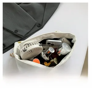 Detailed view of the large interior storage capacity of this white quilted chain bag