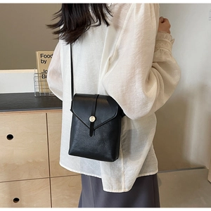 Close-up of black litchi pattern leather phone bag with gold metal buckle detail