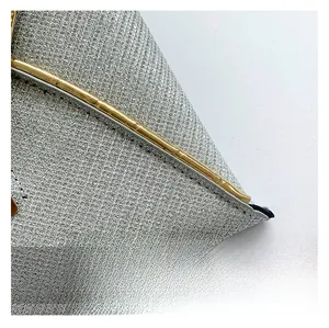 Macro-opname van zilveren glitterstof en gouden metalen rand op de envelop clutch