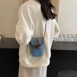 Borsa porta cellulare in denim con finiture in pelle e chiusura a alamaro su modella