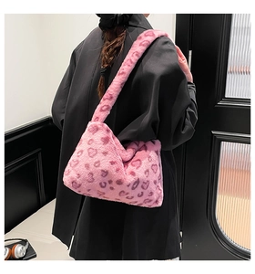 Detailed side view of pink faux fur shoulder bag with purple leopard heart patterns