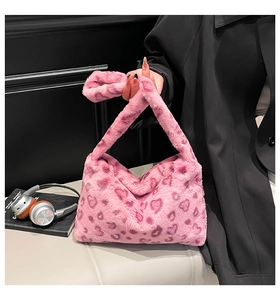Détail d'un sac à bandoulière en fausse fourrure rose avec motifs léopard en forme de cœur