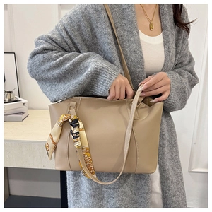 Détail du cabas en cuir beige avec foulard en soie élégant et deux bandoulières