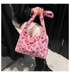 Détail d'un sac à main en fausse fourrure rose avec motif léopard cœur et texture douce