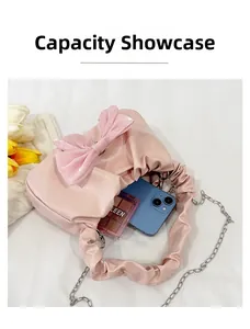 Capacité interne du sac plissé rose montrant le rangement du téléphone et maquillage