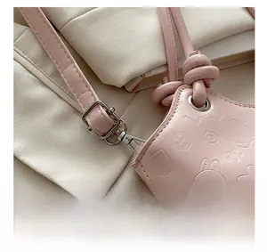 Detail of pink leather bucket bag with embossed rabbit pattern and silver metal hardware