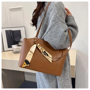 Sac fourre-tout en cuir marron avec foulard en soie porté à l'épaule pour l'échelle