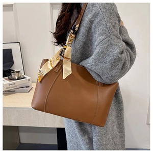 Brown faux leather tote bag with decorative yellow silk scarf and white topstitching detail