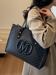 Klassische schwarze Tragetasche mit M-Monogramm-Print und eleganten Goldnieten-Trägern