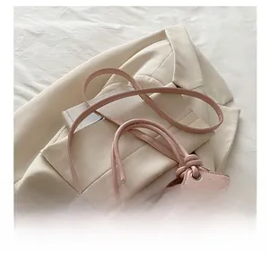 Detail of pink bucket bag with cartoon embossed texture and adjustable thin leather strap