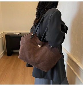 Détail du sac cabas en daim matelassé marron avec fermoir tournant en métal et sangle