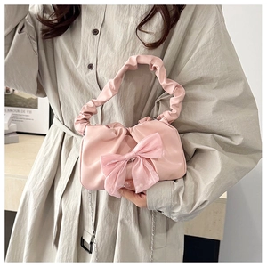 Pink bow handbag featuring cloud pleat handles and a delicate silver chain strap