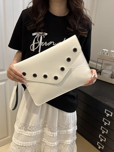 White minimalist envelope clutch bag with black rivet accents and wrist strap for women