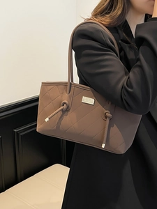 Coffee brown crocodile pattern quilted tote bag worn by model in professional suit