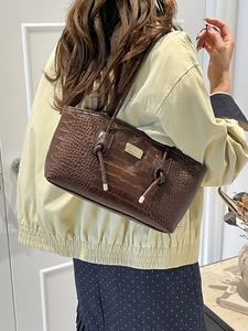 Brown crocodile embossed tote bag for women featuring metal logo plate and knot detail