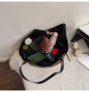 Vue intérieure du grand sac cabas marron montrant le rangement des objets du quotidien
