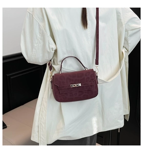 Detail view of wine red leopard print handbag with gold lock and adjustable strap