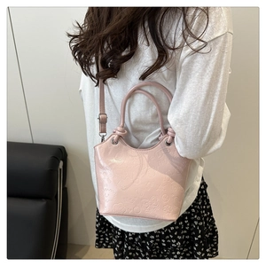 Detailed texture of pink PU shoulder bag with embossed heart and bow patterns