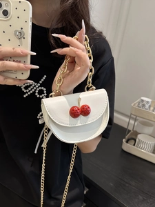 Mini white saddle handbag with red cherry charms and gold chain strap for women