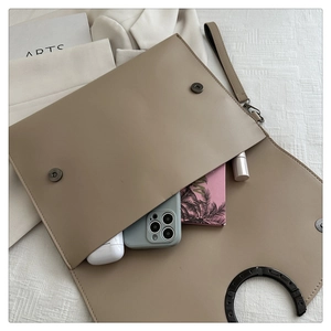 Detail view of the envelope clutch bag showing magnetic closures and interior storage