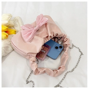 Détail de l'intérieur d'un sac à main rose à nœud montrant sa capacité de rangement
