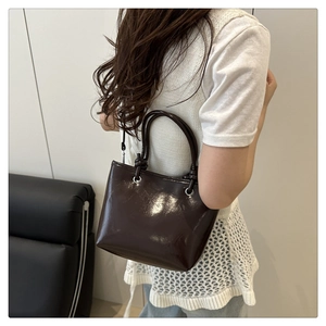 Detail view of glossy dark coffee tote bag with polished finish and round handles