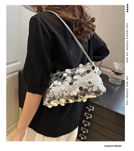 Detail of silver sequin underarm bag showing the reflective material in a lifestyle setting