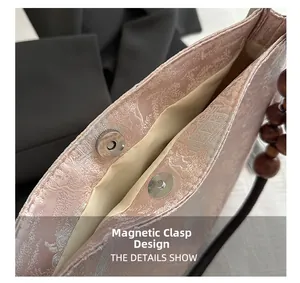 Macro view of magnetic closure on pink floral jacquard shoulder bag with wood bead handle