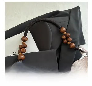 Detail of retro braided shoulder strap with large wooden beads on an embroidered tote bag
