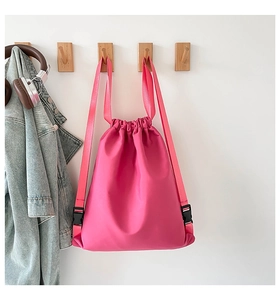 Detailansicht eines rosa Kordelzug-Rucksacks mit verstellbaren Gurten am Haken