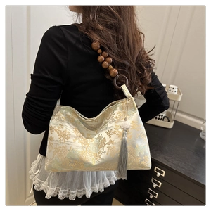 Detail of jacquard handbag with traditional landscape pattern and wooden bead strap