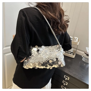 Close-up of silver sequin shoulder bag showing shimmering texture on a female model