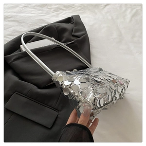 Detail of silver sequin handbag with chain strap and glossy metallic finish