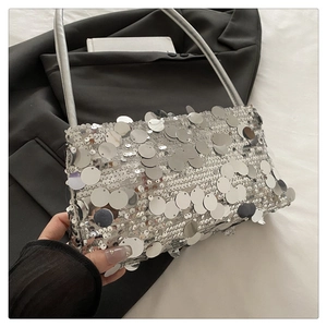 Detailed close-up of a silver sequined handbag with a thin metal chain strap