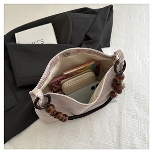 Detail of pink floral jacquard handbag showing spacious interior and wood bead handle