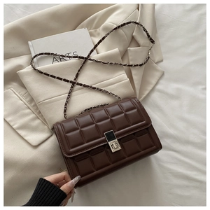 Close-up of brown quilted checkered bag with silver twist lock and chain strap