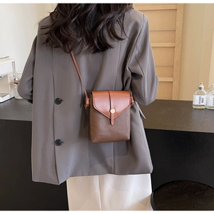 Detailed back view of a person wearing a two-tone brown litchi texture crossbody phone bag