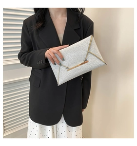 Detail van zilveren glitter envelop clutch met gouden metalen rand en sluiting