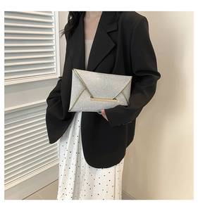 Detail van de zilveren pailletten enveloppe clutch met gouden metalen rand en sluiting