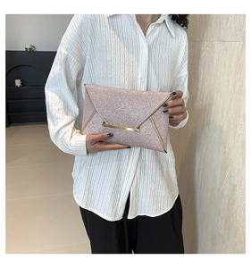 Detail van roségouden glitter envelopclutch met geometrische gouden gesp en lovertjes