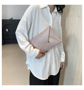 Detail van pailletten enveloppe clutch met gouden bies en roze textuurafwerking