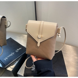 Detail of color-block phone bag showing litchi grain texture and metal buckle