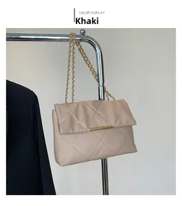Detail of khaki quilted leather crossbody bag with gold chain strap on display