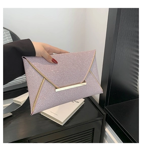 Detail van een roze glitter clutch met elegante goudkleurige metalen rand en gesp